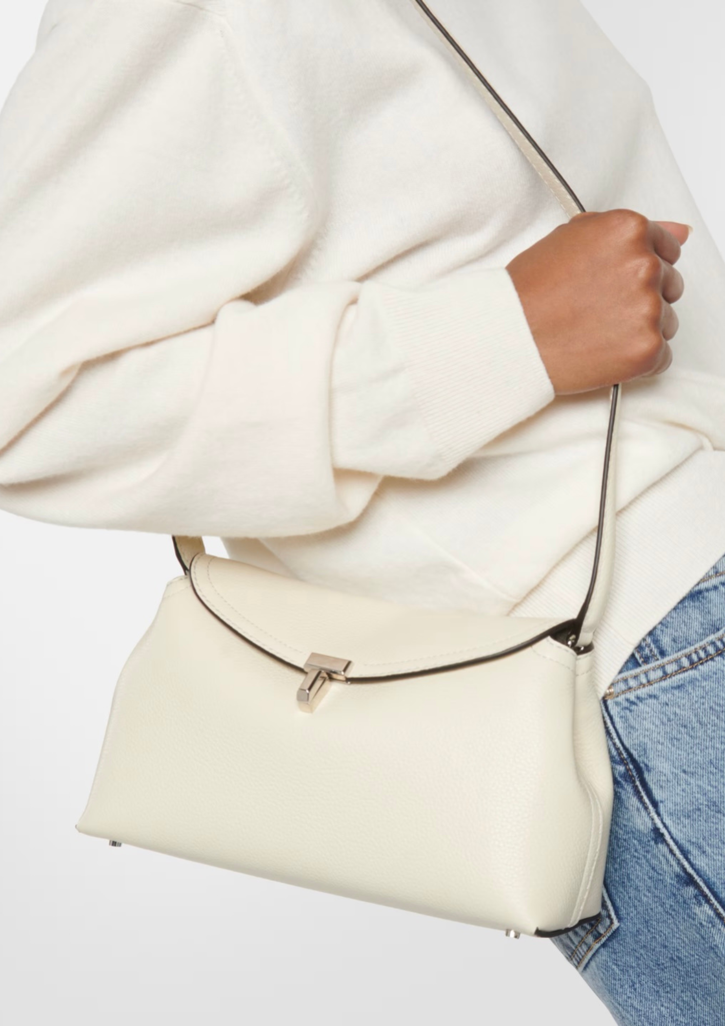 Toteme T-Lock Clutch Milk indossata crossbody con tracolla
