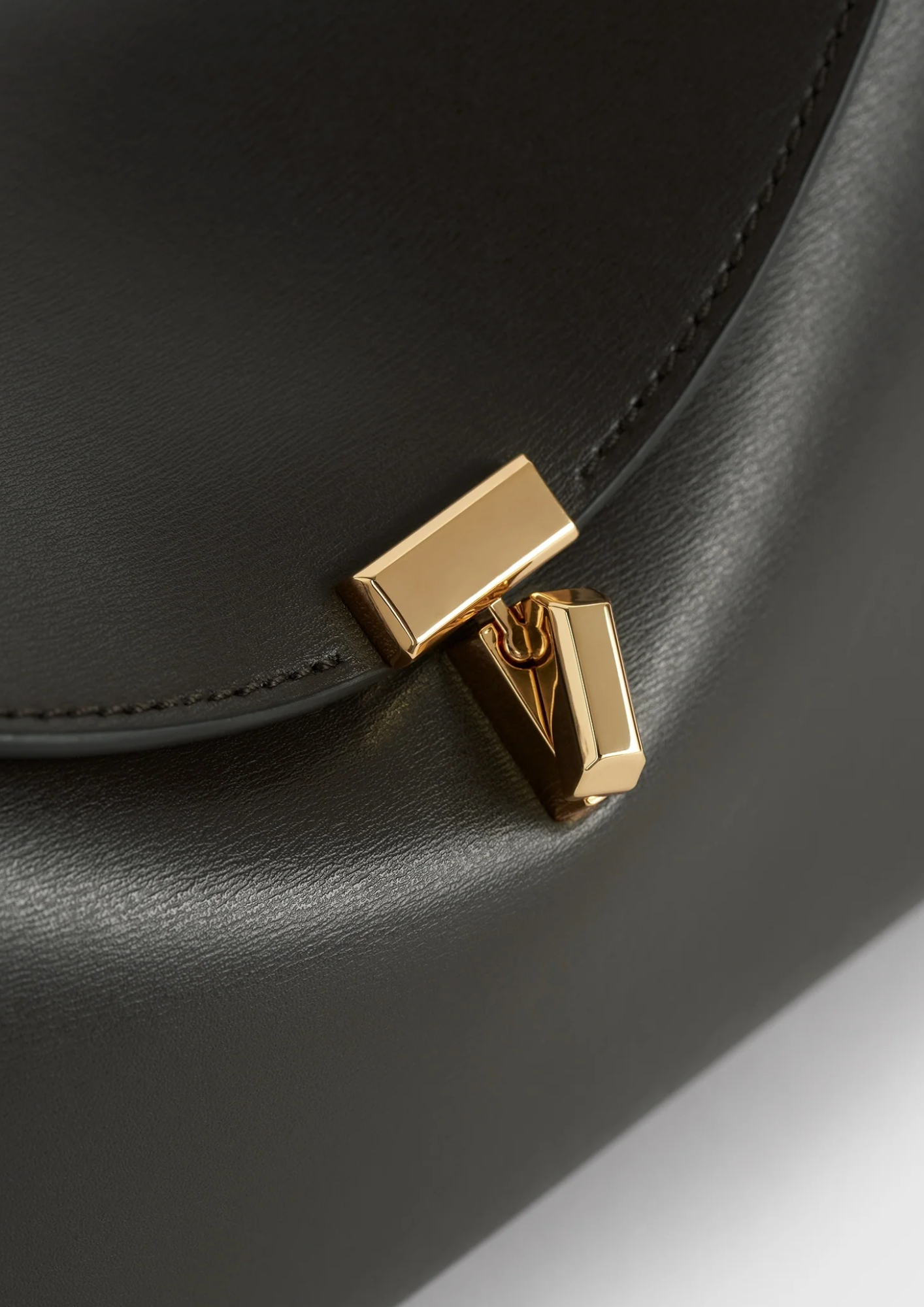 Dettaglio della chiusura T-Lock dorata della borsa Toteme Bark