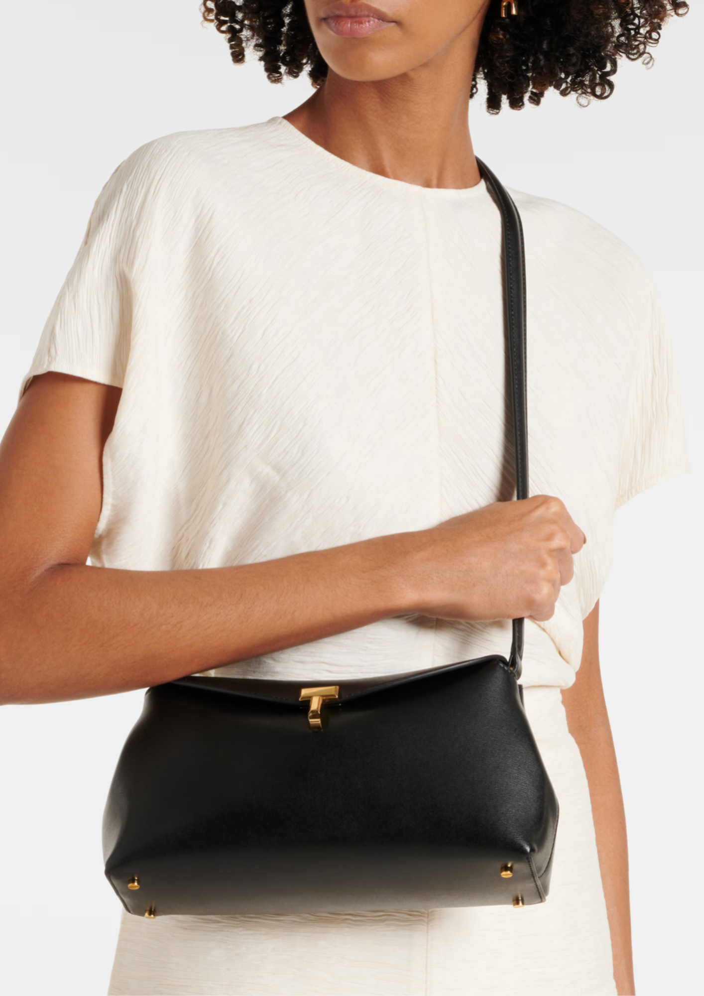 Toteme T-Lock Clutch nera indossata crossbody con tracolla regolabile