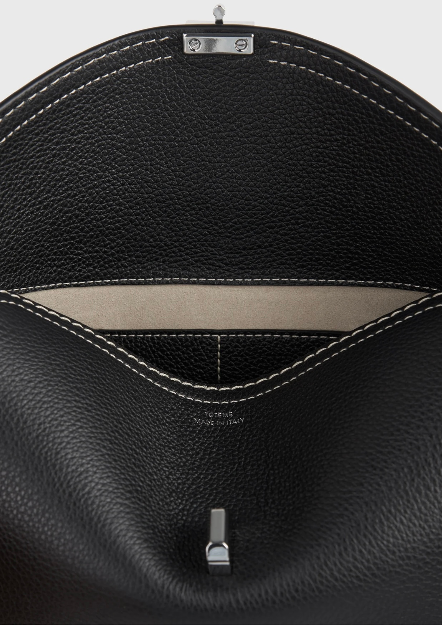 Interno beige in microsuede della Toteme T-Lock Clutch nera