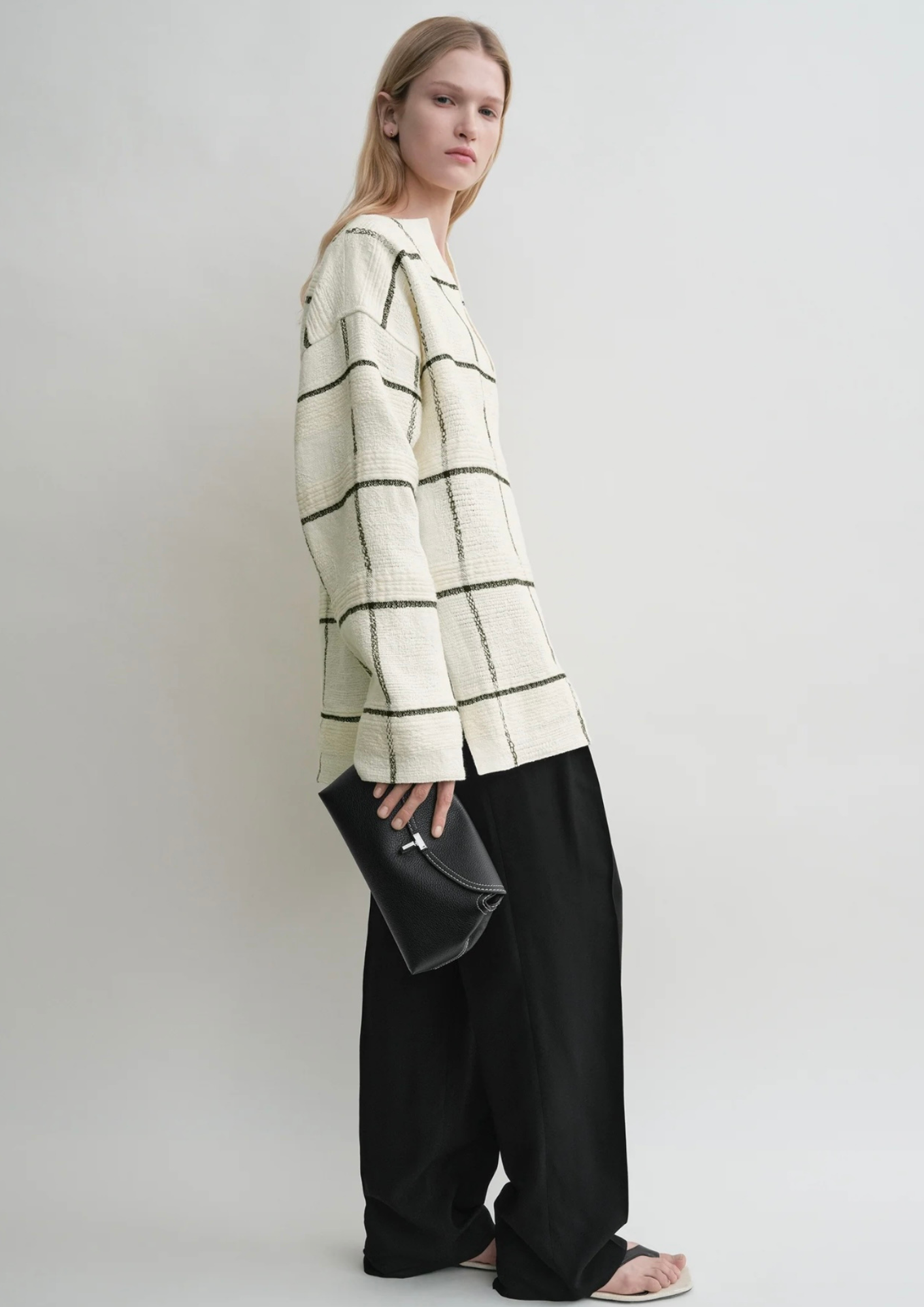 Toteme T-Lock Clutch nera in pelle martellata portata a mano